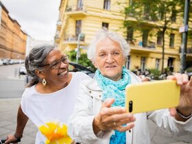 Coverbild Altersbericht - Zwei Damen machen eine Selfie in der Großstadt